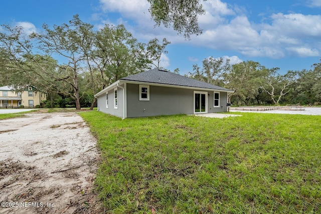 back of property with a patio area and a lawn