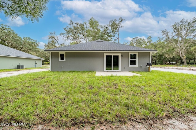 back of property featuring central AC and a yard