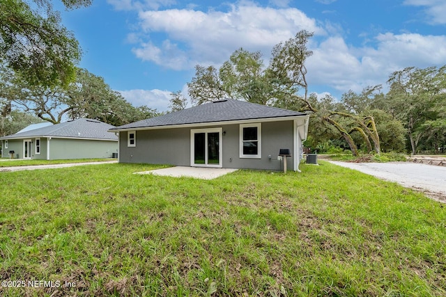 rear view of house with a yard, central AC unit, and a patio area