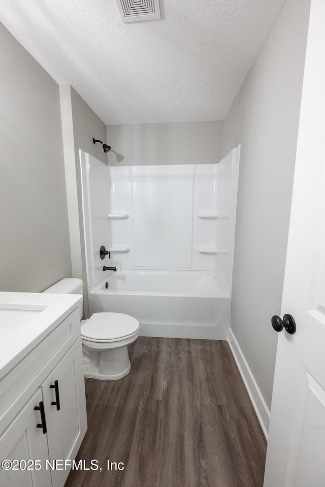 full bathroom with hardwood / wood-style floors, a textured ceiling, shower / bathtub combination, and toilet