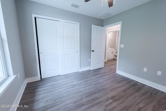 unfurnished bedroom with dark hardwood / wood-style floors, a closet, and ceiling fan