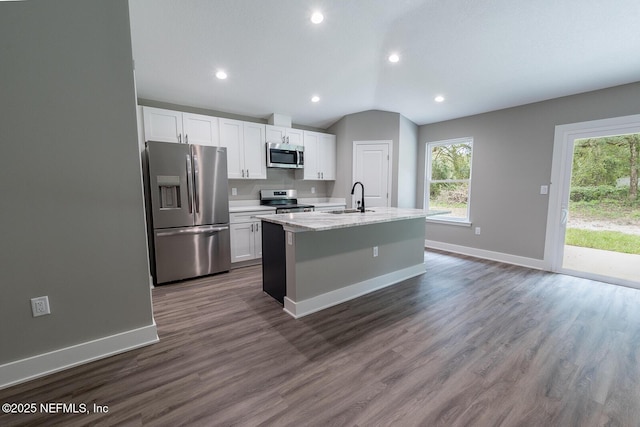 kitchen with appliances with stainless steel finishes, white cabinetry, sink, a kitchen island with sink, and dark wood-type flooring