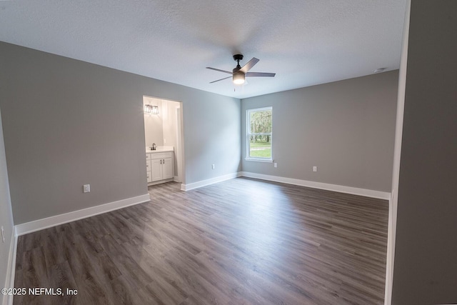 unfurnished room featuring dark hardwood / wood-style flooring, a textured ceiling, and ceiling fan