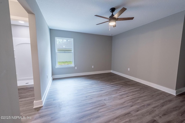 empty room featuring ceiling fan, dark hardwood / wood-style floors, and a textured ceiling