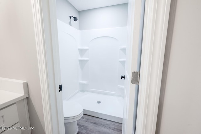 bathroom with vanity, hardwood / wood-style flooring, toilet, and walk in shower