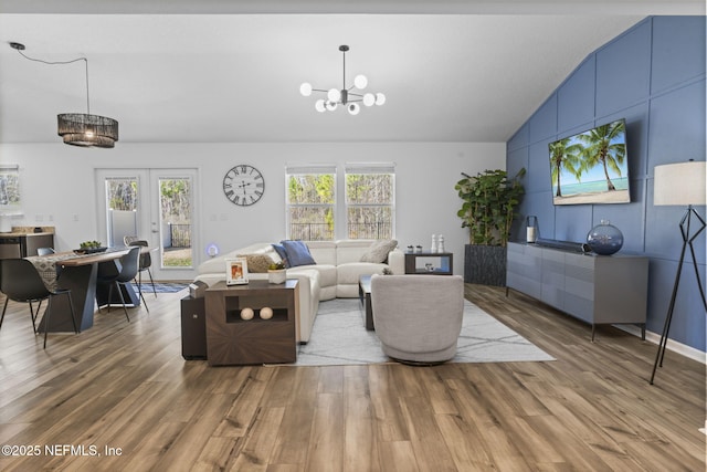 living room featuring hardwood / wood-style flooring, lofted ceiling, plenty of natural light, and french doors