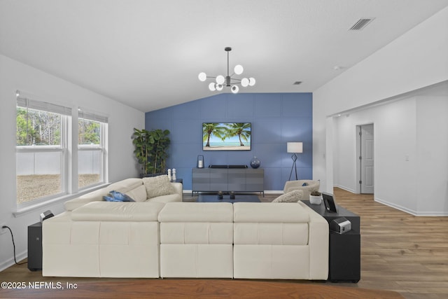 living room featuring lofted ceiling, a chandelier, and hardwood / wood-style floors