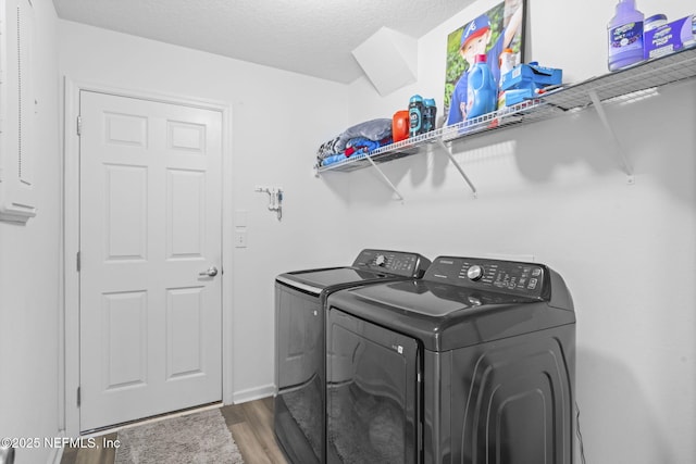 washroom with hardwood / wood-style flooring, independent washer and dryer, and a textured ceiling