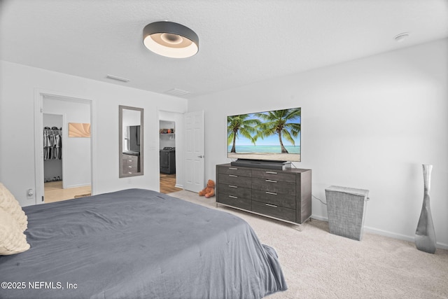 bedroom featuring a walk in closet and light colored carpet