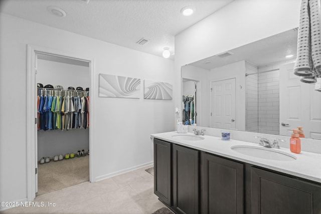 bathroom with vanity, tile patterned flooring, and a textured ceiling