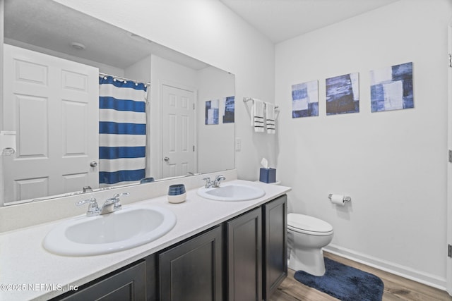 bathroom featuring walk in shower, vanity, toilet, and hardwood / wood-style floors