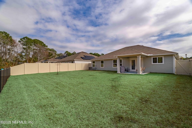 back of property with a yard and a patio area