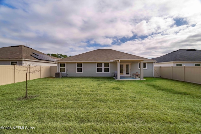 back of property with a yard, central AC unit, and a patio area