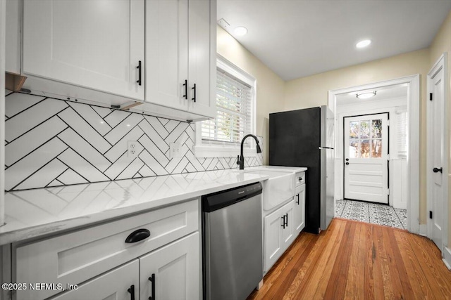 kitchen with white cabinetry, light stone countertops, decorative backsplash, and stainless steel appliances