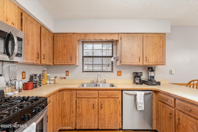 kitchen featuring sink, stainless steel appliances, and a textured ceiling