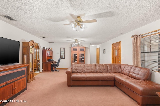 carpeted living room with a textured ceiling and ceiling fan