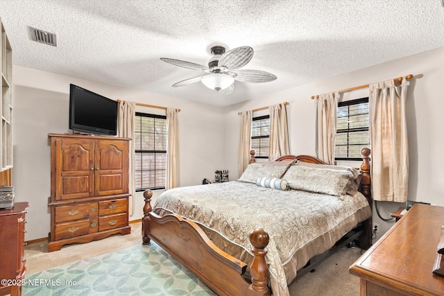 carpeted bedroom with a textured ceiling and ceiling fan