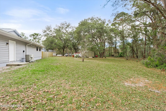 view of yard with a storage shed and central air condition unit