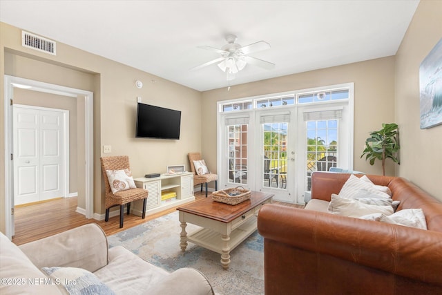 living room featuring french doors, ceiling fan, and light wood-type flooring