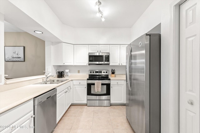 kitchen with sink, light tile patterned floors, white cabinets, and appliances with stainless steel finishes