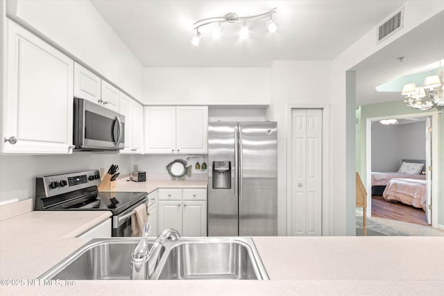 kitchen featuring white cabinetry, stainless steel appliances, light hardwood / wood-style floors, and sink