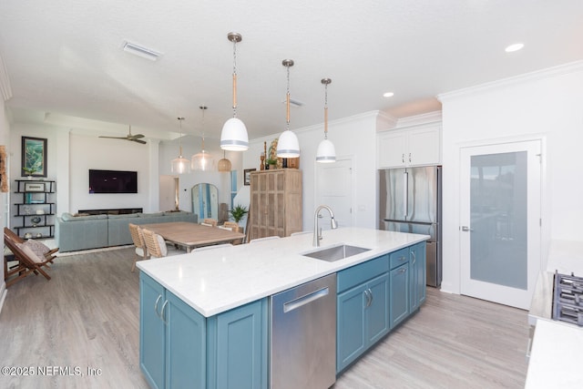 kitchen featuring sink, light hardwood / wood-style flooring, stainless steel appliances, blue cabinets, and decorative light fixtures