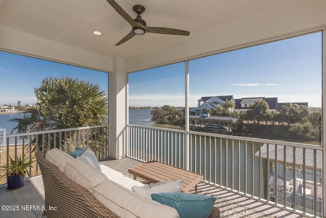 sunroom with a water view and ceiling fan