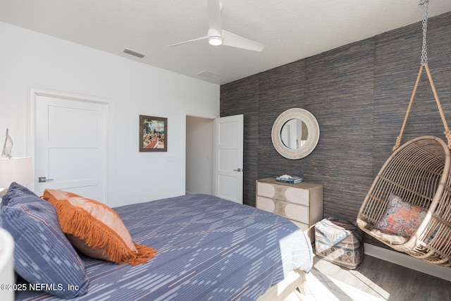 bedroom featuring hardwood / wood-style flooring, a textured ceiling, and ceiling fan