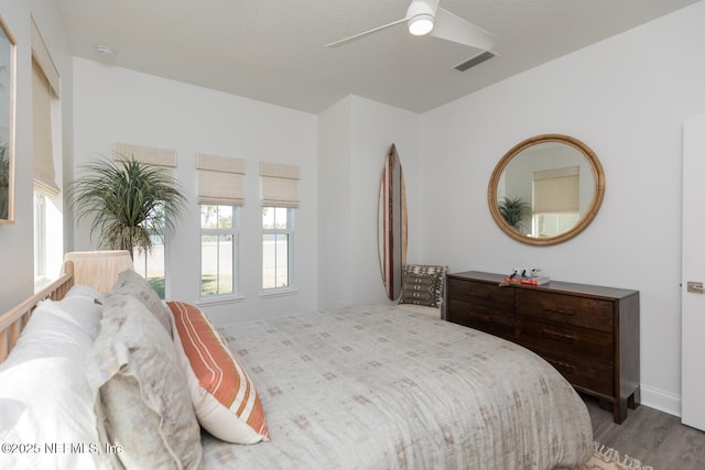 bedroom with dark hardwood / wood-style flooring, a textured ceiling, and ceiling fan