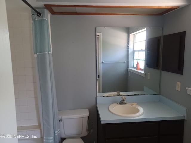 bathroom with curtained shower, vanity, and toilet