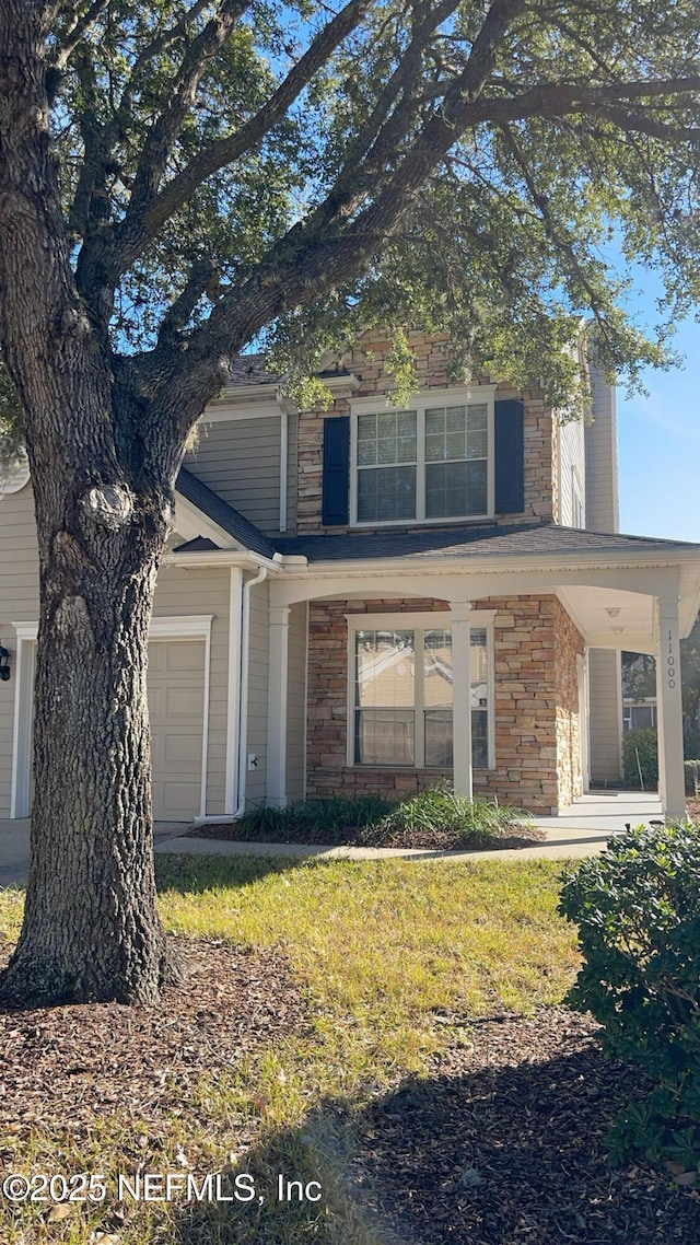 view of front of house with a garage, a front lawn, and a porch