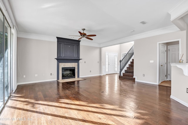 unfurnished living room featuring crown molding, ceiling fan, dark hardwood / wood-style flooring, and a tile fireplace