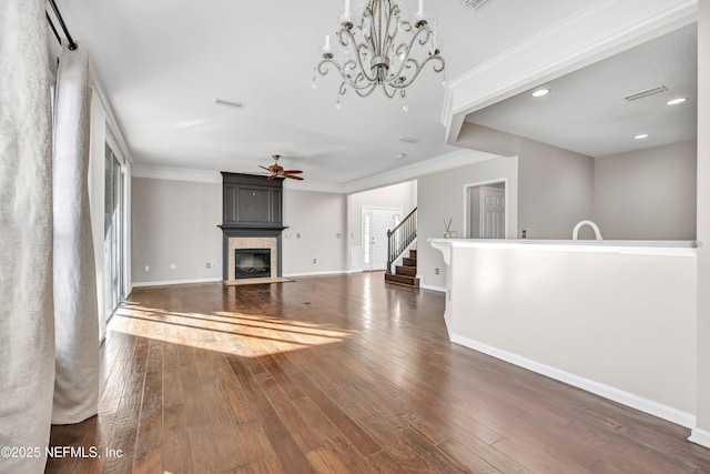 unfurnished living room with crown molding, dark wood-type flooring, and ceiling fan with notable chandelier