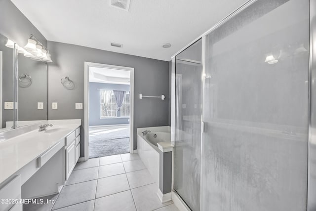 bathroom with vanity, tile patterned flooring, plus walk in shower, and a textured ceiling