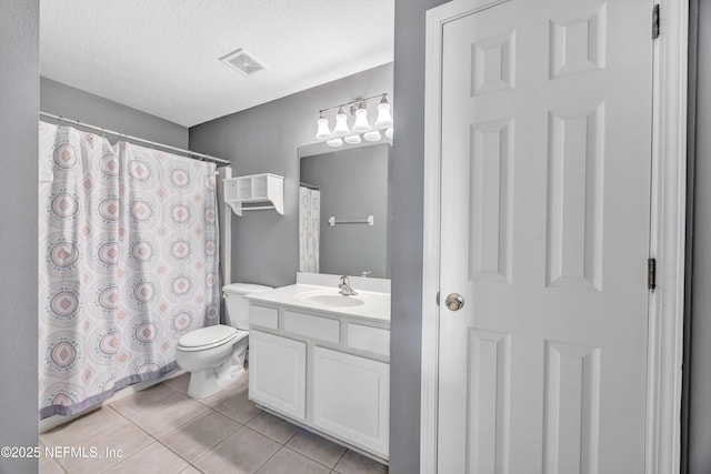 bathroom with tile patterned flooring, vanity, toilet, and a textured ceiling