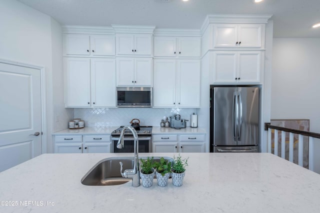 kitchen featuring light stone countertops, appliances with stainless steel finishes, and white cabinets