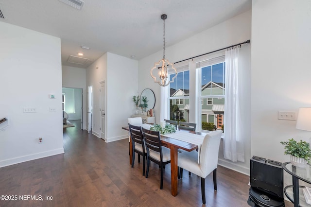 dining space featuring dark wood-type flooring and a notable chandelier