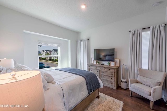 bedroom with dark hardwood / wood-style floors and a textured ceiling