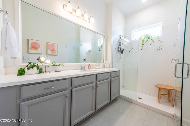 bathroom featuring vanity, tile patterned flooring, and a tile shower