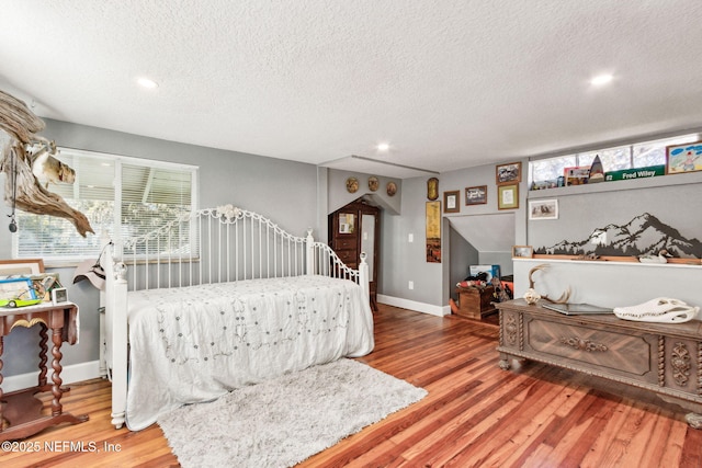 bedroom with hardwood / wood-style floors and a textured ceiling