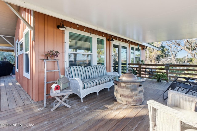 deck with an outdoor living space with a fire pit