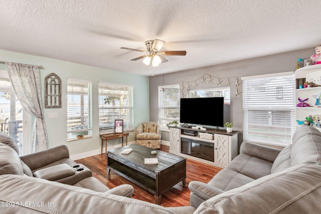 living room featuring hardwood / wood-style flooring, a textured ceiling, and ceiling fan