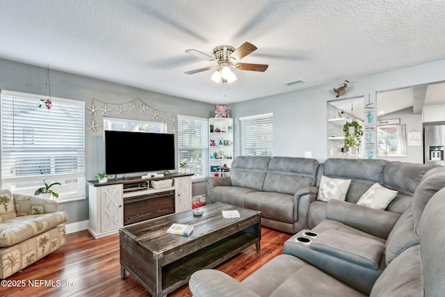 living room featuring ceiling fan, wood-type flooring, and a textured ceiling