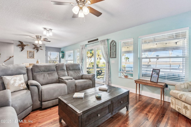 living room with wood-type flooring, ceiling fan, and a textured ceiling