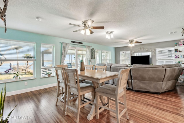 dining area featuring ceiling fan, hardwood / wood-style floors, and a textured ceiling