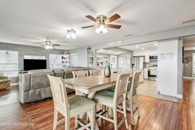 dining area with ceiling fan, a textured ceiling, and light hardwood / wood-style floors