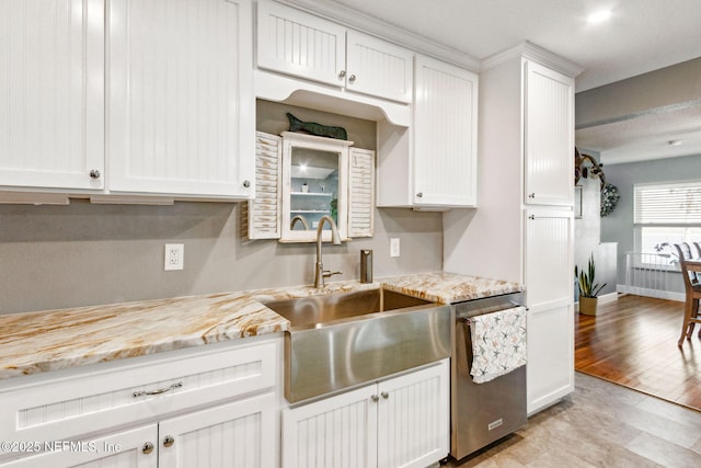 kitchen with light stone countertops, sink, stainless steel dishwasher, and white cabinets