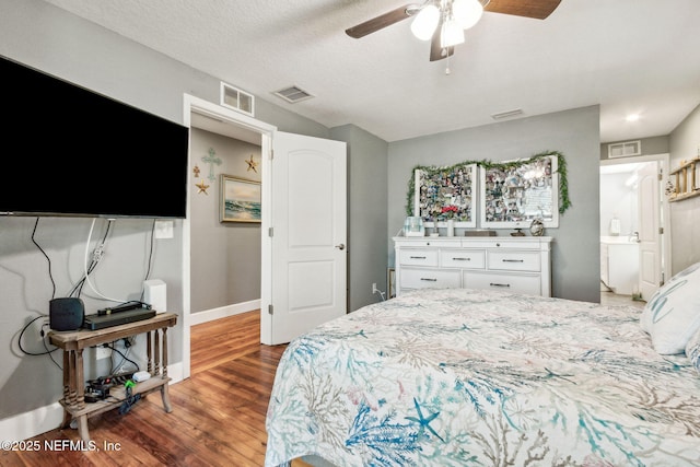 bedroom with ceiling fan, a textured ceiling, and dark hardwood / wood-style flooring