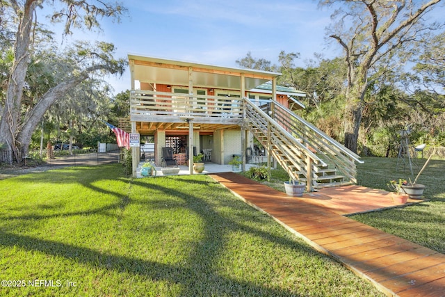 back of house featuring a lawn, a patio, and a deck