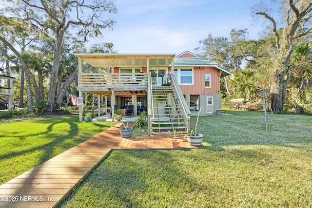 back of property with a wooden deck, a patio, and a lawn